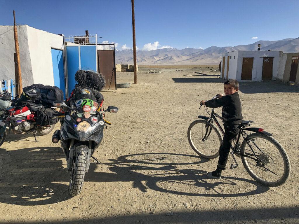 An odd trio: a local boy looks on in Karakul, Tajikistan